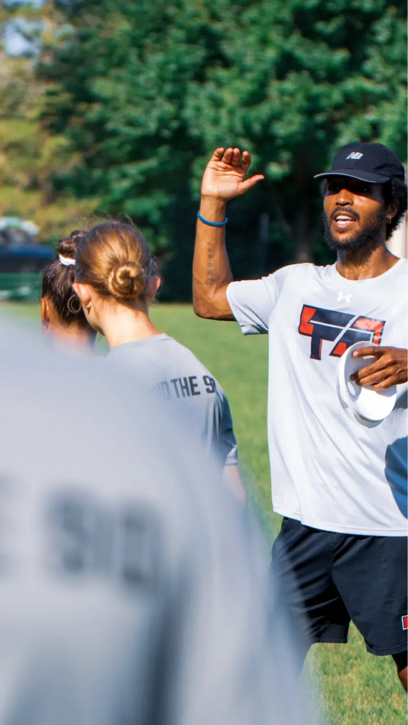 Coach Alex Hood leads players through a training exercise during a summer camp session.