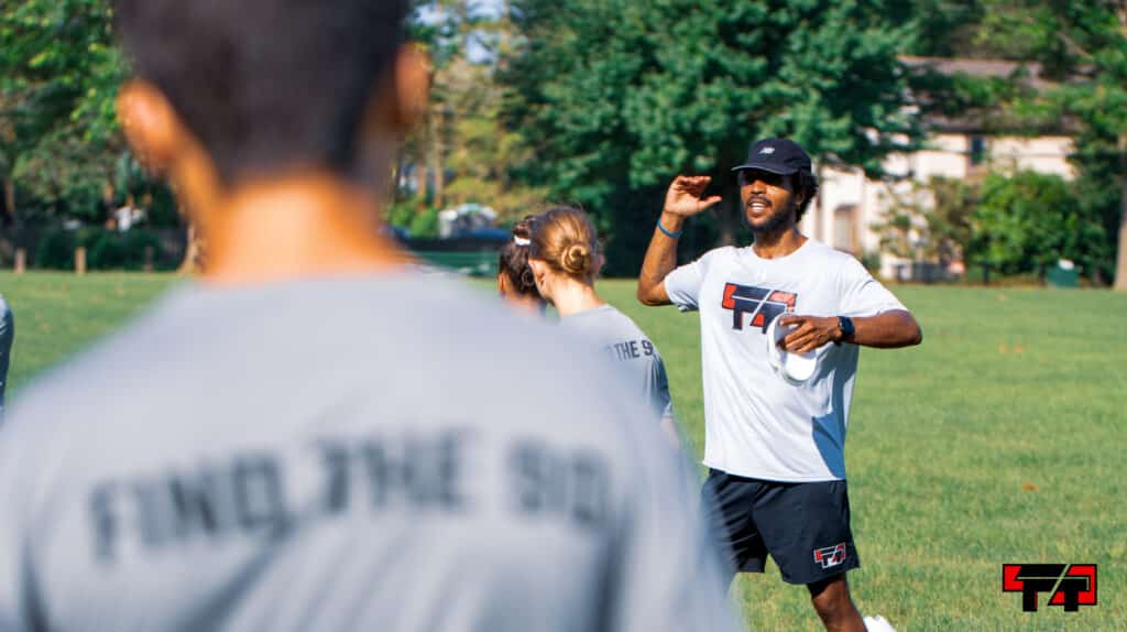 Coach alex hood leads campers through an activity.